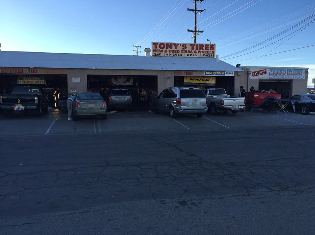 The Tony's Tires storefront in Lancaster, California with tires stacked outside the shop
